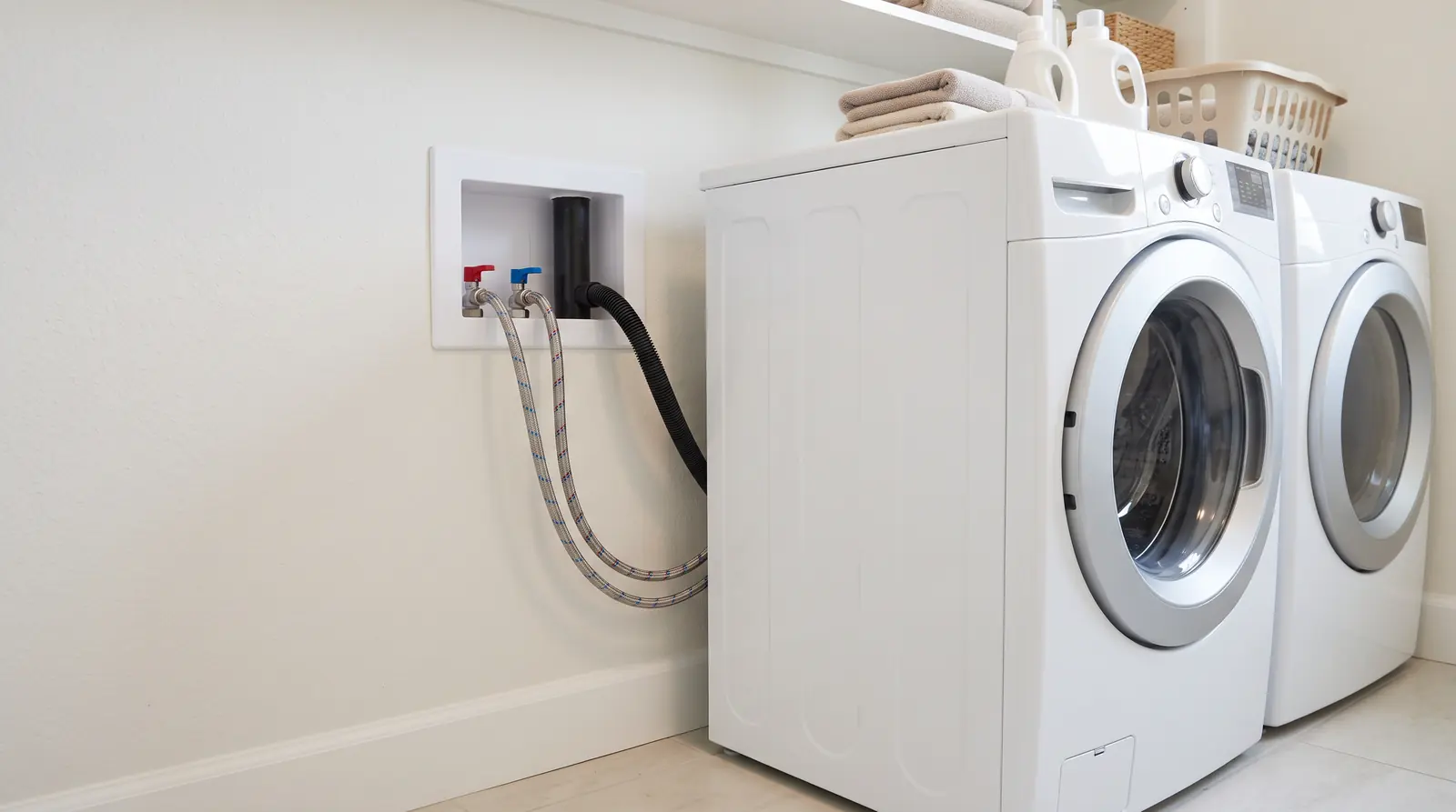 Washing Machine and Laundry Plumbing | Prodigy Plumbing & Drain A bright laundry room with a front-load washer and a recessed wall box with hot and cold shutoff valves and a drain standpipe